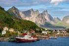 Norway, Reine. Fishing village houses and boats with mountain landscape. Art Print